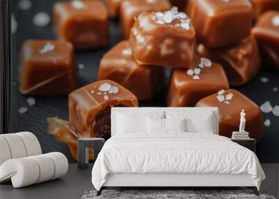 Handful of caramel candies, a few with wrapping opened to reveal salted tops Wall mural