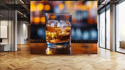 Rocks glass with whiskey and large ice cubes, on a dark wooden bar top Wall mural