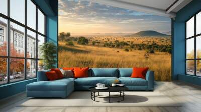 A panoramic view of the Serengeti at dawn, with the savanna bathed in soft golden light. Wall mural