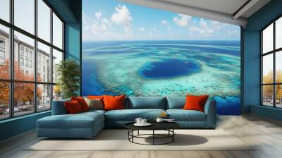 Aerial view of the Great Blue Hole and its surrounding coral atoll, with clear blue skies above. Wall mural