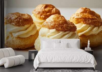 Three cream puffs filled with rich cream, with a golden, flaky exterior. Wall mural