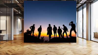 Silhouette of group of friends standing and watching vivid sunrise on mountain in morning. Success of tourist trekking group with sunrise background. Wall mural