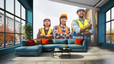 Caucasian man and asian woman of engineering team are standing with crossed arms and looking forward confidently in a successful job.	 Wall mural