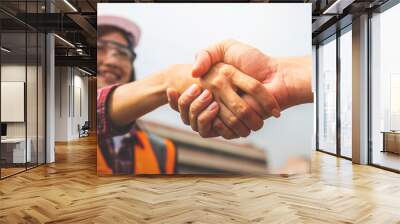 Two engineer shaking hands with deals and congratulations on success. Wall mural