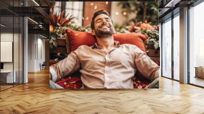 A man is smiling and laying on a red pillow Wall mural