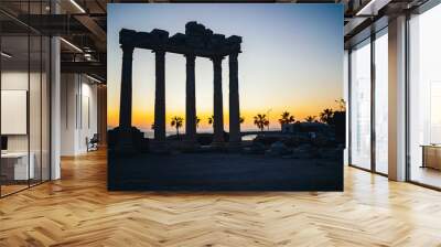 Side, Turkey. View from below of ancient ancient ruins of the Temple of Apollo with yellow sunset sky in the background during sunset. Manavgat, Turkey. Wall mural