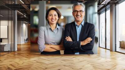 Happy, smiling, confident, professional, mature Latin businessman and Asian business woman, colleagues, corporate managers standing in the office, two diverse executives team arms crossed, portrait.  Wall mural