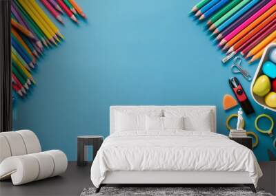 creative arrangement of school supplies such as colored pencils, erasers, and scissors on a clean surface, with space for writing and copy space for text Wall mural