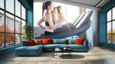 Attractive asian sport women running on treadmil with friend in sport gym Wall mural