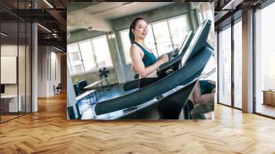 Attractive beautiful smiling women work out by running on treadmill Wall mural