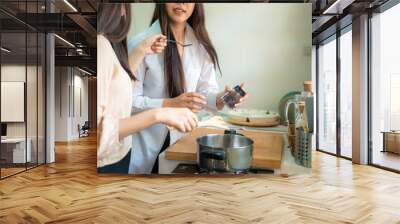 Happy asian women cooking in kitchen together morning meal Wall mural