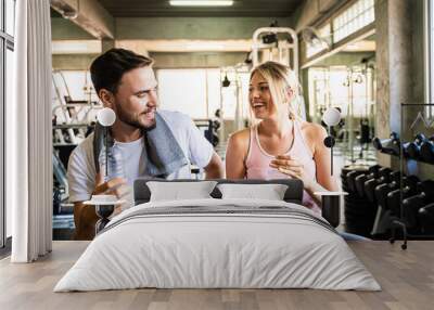 Happy couple drinkking water after exercise in sport fitness gym Wall mural