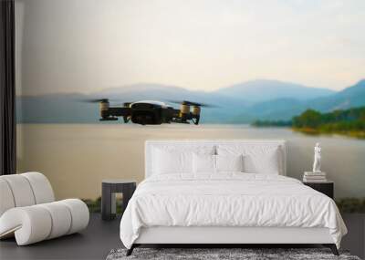 Silhouette drone flying over lake sunset Wall mural