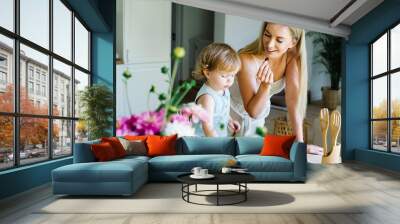 Young beautiful mother spending time with baby daughter in dining room at home. Wall mural