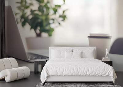 A clean and modern stock photo of a minimalist workspace featuring an open laptop and a coffee cup on a sleek, white desk. Wall mural