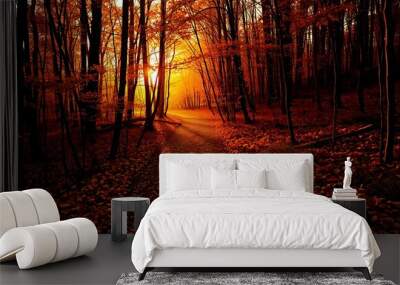 A narrow path through a dense autumn forest is bathed in warm, golden light. Wall mural