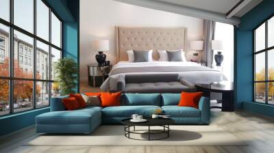 The room has an elegant bed with a beige headboard, grey curtains on each side of it, two lamps beside the bed, a gray bench at the foot end of the bed and a black coffee table near the window.	 Wall mural