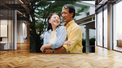 Asian senior couple hugging outdoors in backyard. Wall mural