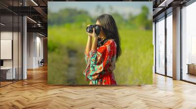 sweet young Asian Chinese or Korean woman on her 20s taking picture with photo camera smiling happy in beautiful nature landscape in holidays Wall mural