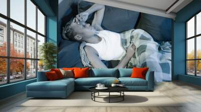 young afro American girl at night suffering depression problem - attractive sad and depressed black woman lying thoughtful and depressed on sofa couch in pain Wall mural