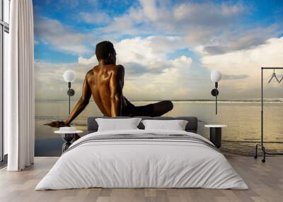 young attractive and relaxed black afro American man with fit body and muscular back sitting on beach sand enjoying beautiful view thinking and meditating free Wall mural