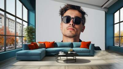 A portrait of a good looking young man in black sunglasses against a white studio backdrop Wall mural