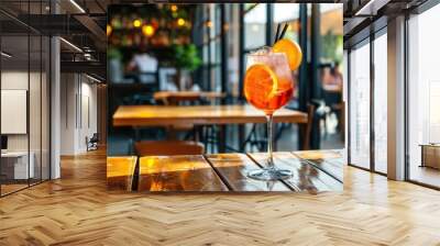 Aperol spritz cocktail on wooden table in cafe Wall mural