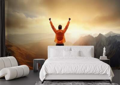 Energetic man in orange, celebrating success with mountain view. Wall mural