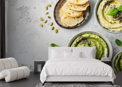 Mixed mung bean dip with seeds mint grissini or bread sticks and green hummus on light grey background Wall mural