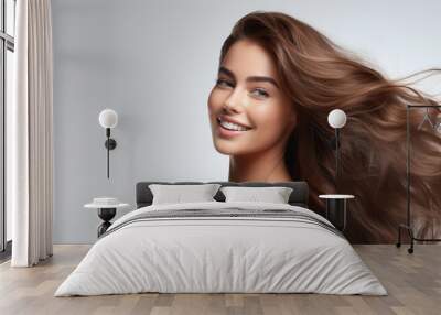 The beautiful woman with flawless hair is captured in a happy portrait her face glowing against the white background while showcasing her natural beauty and healthy lifestyle Her makeup enha Wall mural