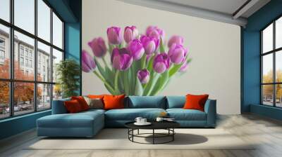 Vibrant purple tulips in clear vase against neutral backdrop Wall mural