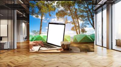 Businessman working with of laptop with blank white screen and coffee view Outdoors of Abstract Tourist in forest camp among meadow background. Wall mural