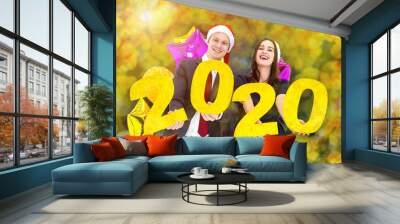 Happy new year 2020 concept. Couple a business suit of man hold in hand year 2020 label and colourful balloon with happiness face celebrating new party on Yellow Colorful circular bokeh background Wall mural