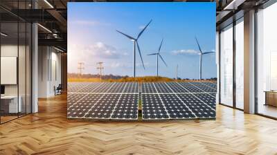 solar panels with wind turbines against mountanis landscape against blue sky with clouds,Alternative energy concept,Clean energy,Green energy. Wall mural