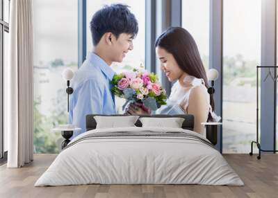 Valentine's day concept,asian Young happy sweet couple holding bouquet of red and pink roses After lunch In a restaurant background,Love story couple Wall mural