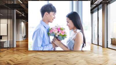 Valentine's day concept,asian Young happy sweet couple holding bouquet of red and pink roses After lunch In a restaurant background,Love story couple Wall mural