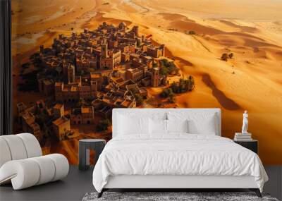 Aerial view of a medieval village nestled in golden sand dunes during bright midday light in a vast desert landscape, a lonely village far from any civilization Wall mural