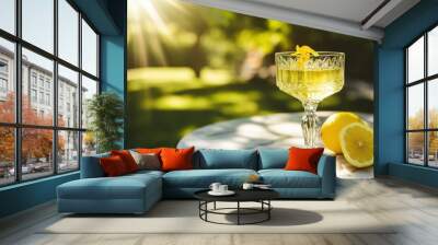 A crystal glass of Italian limoncello with a lemon zest garnish, placed on a marble table in a sunlit garden Wall mural