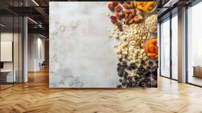 A flat lay of various dried fruits, seeds, and grains on a light surface, copy space on the side. Wall mural