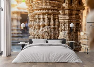 Intricately carved stone pillars of an ancient Indian temple, with detailed patterns and motifs. Wall mural