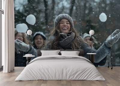 A group of friends having fun in the snow, throwing snowballs at each other and laughing Wall mural