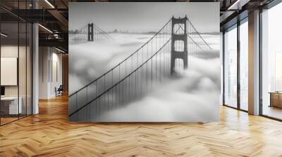 The Golden Gate Bridge under a blanket of fog with only the tips of its towers visible, creating a hauntingly beautiful and mysterious scene Wall mural