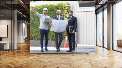 Engineers are on site at the construction site. Engineer present new ecology project. around solar panel for roof. Hand holding a solar panel. young man pointing fingers. Wall mural