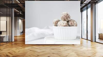 Coconut and chocolate truffles in white ramekin, homemade chocolate bonbons on white background, desiccated coconut coated truffles	 Wall mural