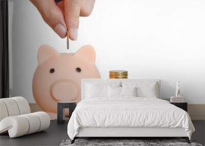 money saving concept. business hand putting golden coin in to piggy bank with stack coins on wood table isolated on white background for save and investment. financial and banking. Wall mural