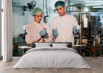 Specialist in factory checking bottles. Two female worker inspecting quality of plastic water tank on conveyor belt in drinking water factory. Wall mural