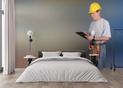 Building worker with tool belt taking notes Wall mural