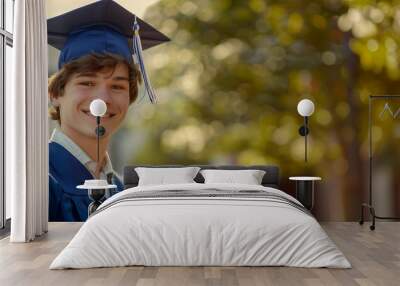 Happy young graduate holding diploma outdoors on a sunny day Wall mural