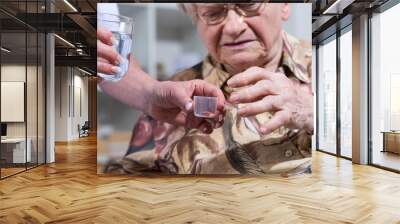 Nurse giving medication to a senior woman Wall mural