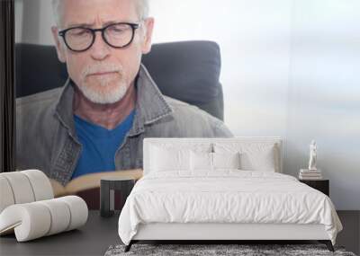 Portrait of mature man reading a book Wall mural